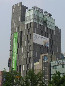 un edificio alto con letreros a un lado. en Urban Boutique Hotel, en Anyang