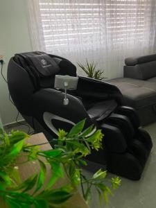 sala de estar con silla y sofá en Snow View Suite סוויטת סנו וויו, en Majdal Shams