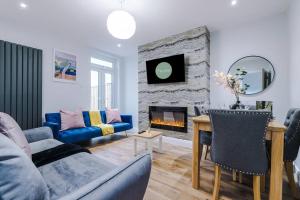 a living room with a couch and a fireplace at Stunning Designer House with Parking Sleeps 8 by PureStay Short Lets & Serviced Accommodation Liverpool in Litherland