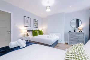 Litherland的住宿－Stunning Designer House with Parking Sleeps 8 by PureStay Short Lets & Serviced Accommodation Liverpool，一间卧室配有两张床和镜子