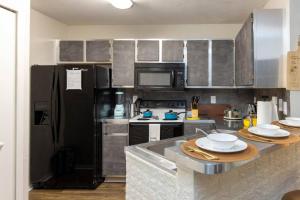 a kitchen with stainless steel appliances and a black refrigerator at Stylish Serenity: Your Central Peace Zone! in Gainesville