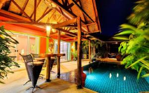 a swimming pool in a house with a table at Chaba Pool Villa in Nai Harn Beach