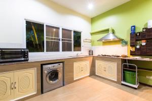 a kitchen with a washer and dryer in it at Chaba Pool Villa in Nai Harn Beach