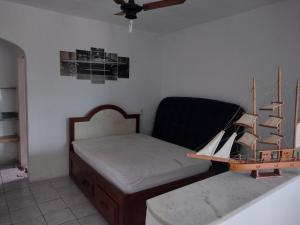 um pequeno quarto com uma cama e uma mesa em Kitnet temporada Cabo Frio em Cabo Frio