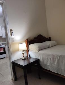 een slaapkamer met een bed en een tafel met een lamp bij Alojamiento en La Ceiba in La Ceiba