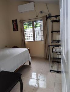 a bedroom with a bed and a window and a shelf at Alojamiento en La Ceiba in La Ceiba