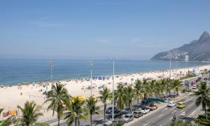 uma praia com palmeiras e multidões de pessoas em Tabas Lindo em frente a Praia de Ipanema IP0007 no Rio de Janeiro