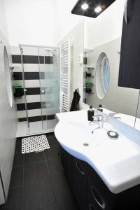 La salle de bains est pourvue d'un lavabo blanc et d'un miroir. dans l'établissement JAZZ! Super Central Cozy Downtown, à Budapest