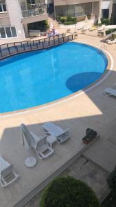 een zwembad met 2 ligstoelen en een zwembad bij Side Oasis Residence 2+1 (Manavgat/Antalya). in Side