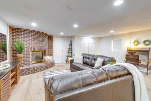 a living room with a leather couch and a fireplace at Aurora Vacation Rental 9 Mi to Downtown Denver in Aurora