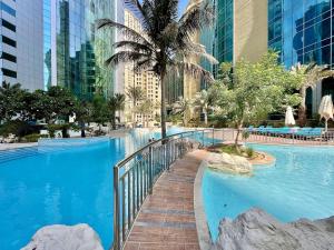 a large swimming pool in a city with tall buildings at AR Holiday Home JBR in Dubai