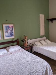 2 camas en una habitación con paredes verdes en BH Studio Casa grande em Fortaleza, en Fortaleza