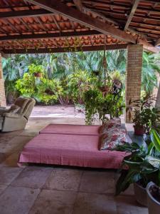 a large bed on a patio with plants at BH Studio Casa grande em Fortaleza in Fortaleza