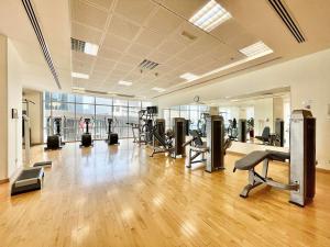 a gym with several treadmills and machines in a room at AR Holiday Home JBR in Dubai