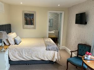 a bedroom with a bed and a desk and a chair at The Whitehouse Ross-On-Wye in Ross on Wye