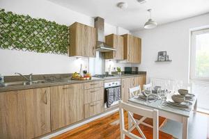 a kitchen with wooden cabinets and a table with chairs at Luxury 2 Bedroom 2 Bathroom Apartment - City Centre - Free Parking, Balcony and Smart TVs with Sky TV and Netflix by Yoko Property in Milton Keynes