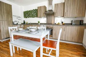 a kitchen with a white table and chairs in a room at Luxury 2 Bedroom 2 Bathroom Apartment - City Centre - Free Parking, Balcony and Smart TVs with Sky TV and Netflix by Yoko Property in Milton Keynes