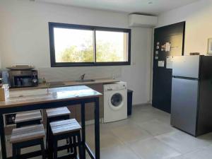 a kitchen with a refrigerator and a washing machine at La Perrière in Pézenas