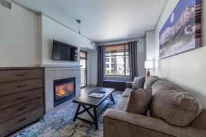 sala de estar con sofá y chimenea en #501-Pet Friendly, 1 Bedroom, Remodeled Village Monache Condo en Mammoth Lakes