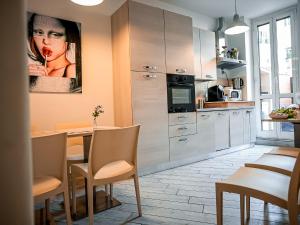 a kitchen with a table and a painting of a woman at Casa Celestina in Rome