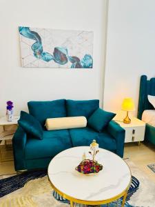 a living room with a blue couch and a table at Cozy Apartment in Jumeirah Village circle, Dubai. in Dubai