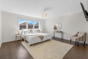 a white bedroom with a bed and a window at Luxury 6 Bedroom - 4 Bathroom Detached Retreat Brampton / Mississauga Border in Brampton