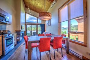 a kitchen with a wooden table and red chairs at Le Grand R in Saint-Donat-de-Montcalm