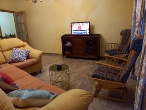un soggiorno con divano e TV di Alojamiento Vacacional Inma parking gratis a Cazorla