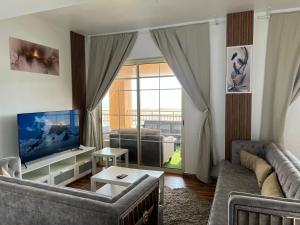 sala de estar con sofá y ventana grande en رويال مارينا 2 بانوراما علي البحر مباشر عوائل فقط, en King Abdullah Economic City