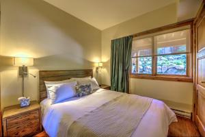 a bedroom with a large bed and a window at Le Grand R in Saint-Donat-de-Montcalm