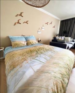 ein Schlafzimmer mit einem Bett mit Vögeln an der Wand in der Unterkunft Studio Sea View - Royal Ascot in Ostende
