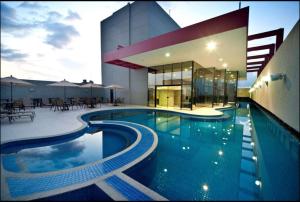 a large swimming pool in front of a building at Flat no Hotel Radisson in Belém
