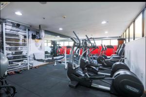 a gym with several tread machines and red chairs at Flat no Hotel Radisson in Belém