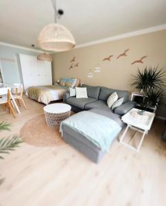 ein Wohnzimmer mit Sofa und Vögeln an der Wand in der Unterkunft Studio Sea View - Royal Ascot in Ostende