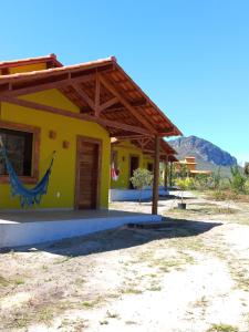 uma casa amarela com uma pintura ao lado em Recanto Cachoeiras de Ibicoara em Ibicoara