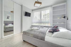 a bedroom with a large bed and a large mirror at Apartament Doris 1 z pięknym widokiem in Pobierowo