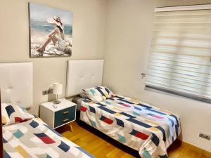 ベナルマデナにあるSeñorío Torrequebradaのベッドルーム1室(ベッド2台付)が備わります。壁には絵画が飾られています。