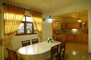 una cucina con tavolo e sedie e una cucina con finestra di Resort Beam a Kandy