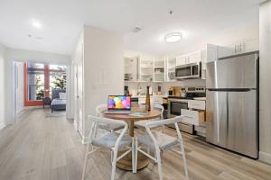 a kitchen and dining room with a table and a refrigerator at The Lofts on Clematis 203 Downtown West Palm Beach in West Palm Beach