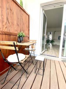 a wooden deck with a table and chairs on a porch at Modernes Trierer CityLoft mit großem Balkon in Trier