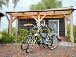 due biciclette parcheggiate di fronte a una cabina di Bed & Breakfast Bij de Wilg a Laren