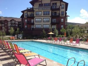 um hotel com uma piscina com cadeiras e um edifício em Upper Ranch em Granby