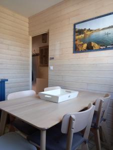 a dining room table with chairs and a picture on the wall at Sous les toits de Saint-Enogat in Dinard