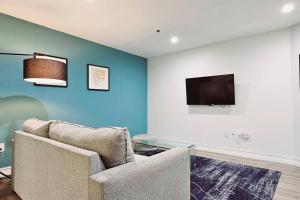 a living room with a couch and a flat screen tv at The Lofts on Clematis 204 Downtown West Palm Beach in West Palm Beach