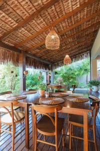 a dining room with tables and chairs and a wooden ceiling at Casa Mar Campeche in Florianópolis