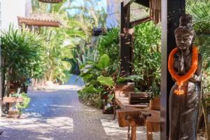 une statue d'une femme debout dans un jardin dans l'établissement Casa Mar Campeche, à Florianópolis