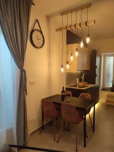 een keuken met een tafel en stoelen en een klok bij Cocon Lux au centre de Voiron in Voiron