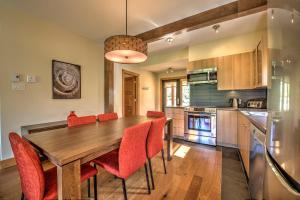 a kitchen with a wooden table and red chairs at Le Grand R in Saint-Donat-de-Montcalm