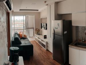 巴西利亞的住宿－Seu espaço em Brasília，厨房配有黑色沙发和冰箱