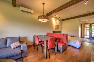 a living room with a table and chairs and a bed at Le Grand R in Saint-Donat-de-Montcalm